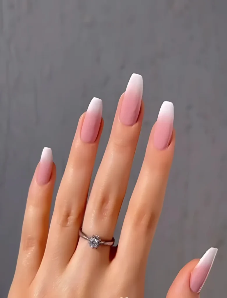 Pink and white ombre nail art design with a subtle gradient and elegant ring